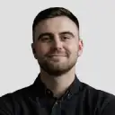 Dispatcher smiling while using scheduling software on a laptop.